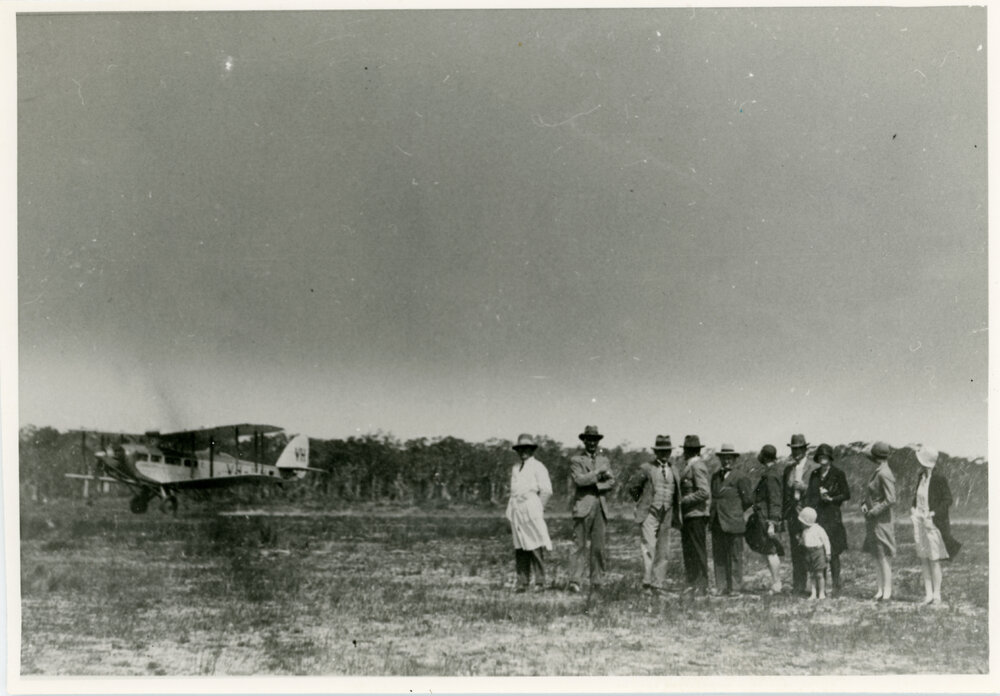 Group of people with aircraft in the background