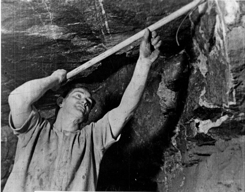 Ramming home the charge with a ramrod made from a broom handle, Damifino Mine. c. 1948