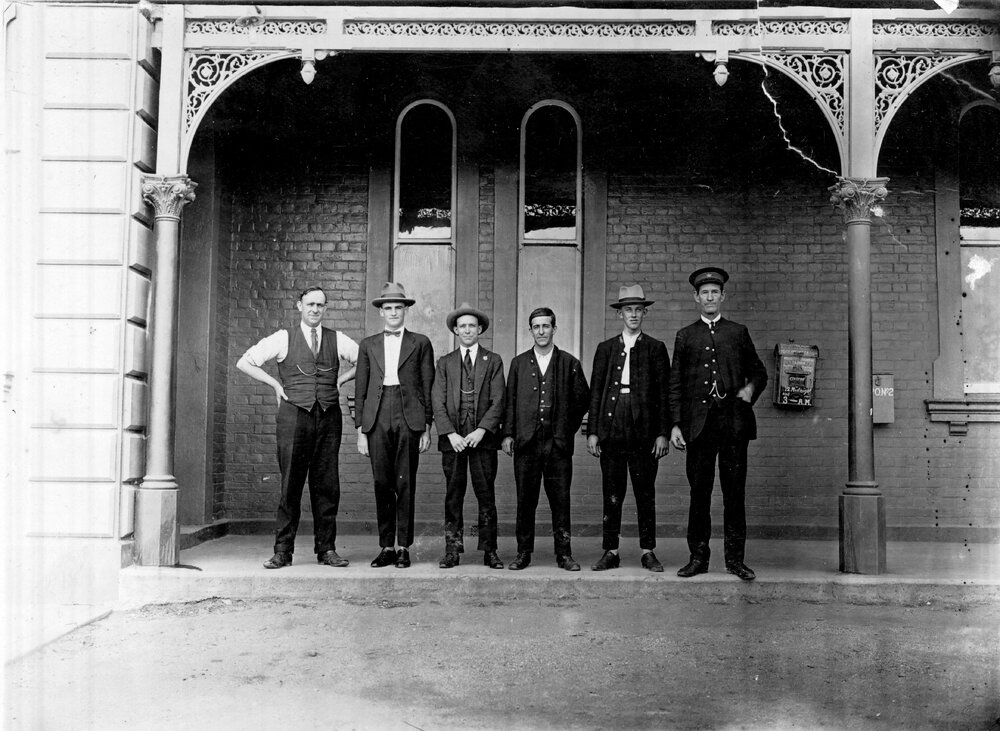 Six men on railway station verandah
