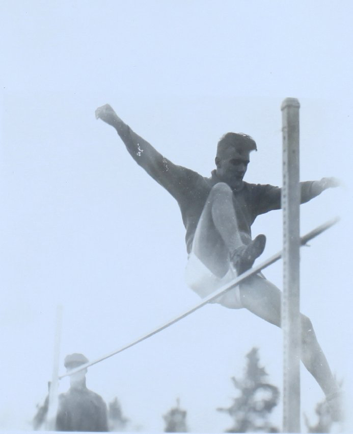 Male student going over a high jump