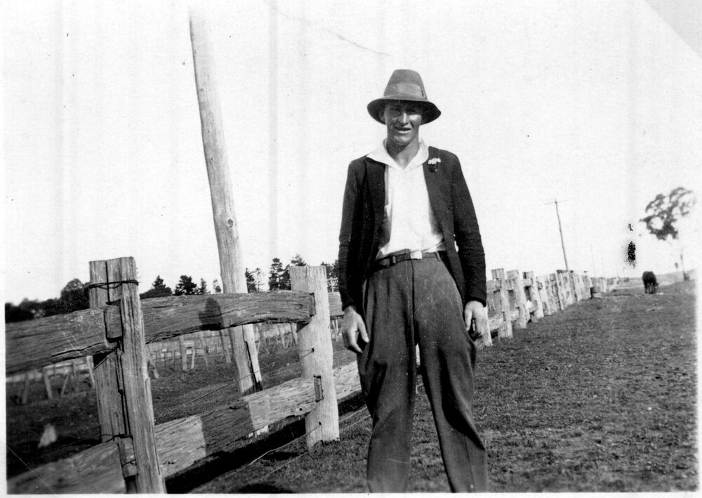 Mr Barry standing beside a post and rail fence, c. 1930