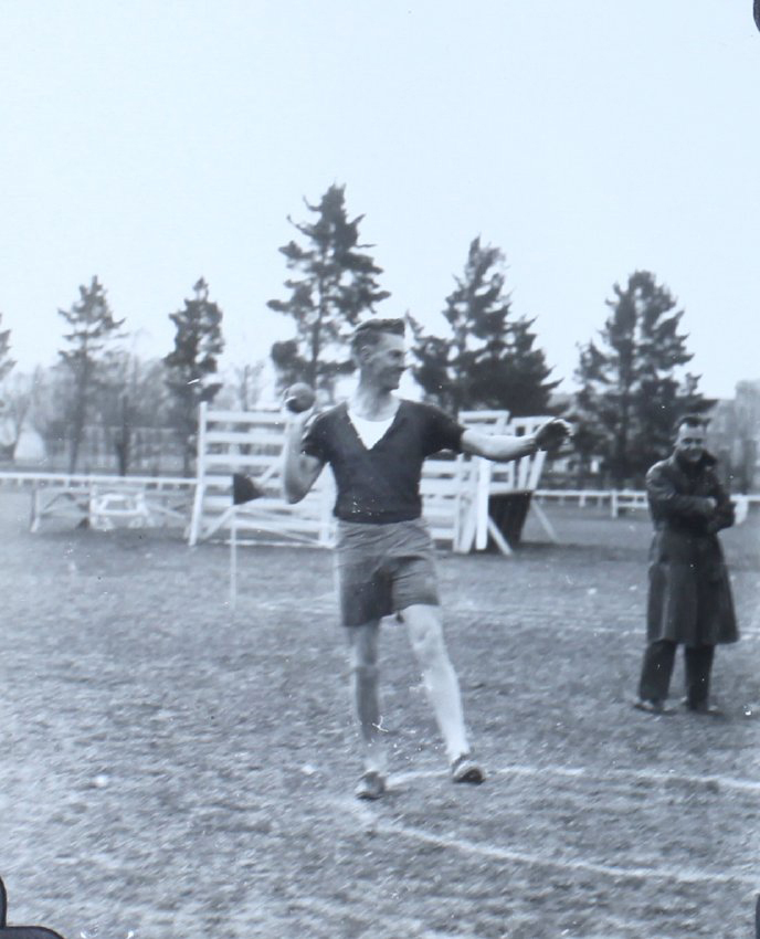 Male student commencing a shot putt throw
