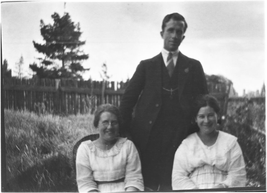 Unidentified man [with RSL badge] standing behind two women