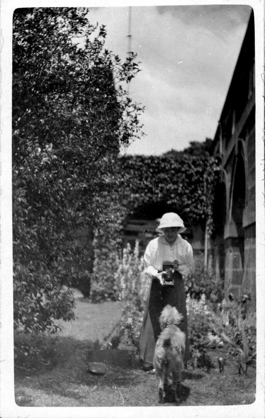 A woman photographing and a dog