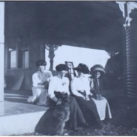 Four women on a verandah with a dog