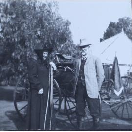 Unidentified couple standing beside a buggy