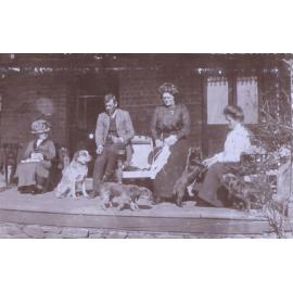 Three unidentified women and one man with pet dogs