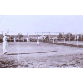 Two undentified man and two women playing tennis