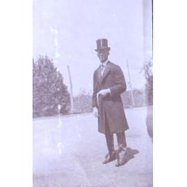 Unidentified man in top hat long coat