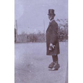 Unidentified man in top hat long coat