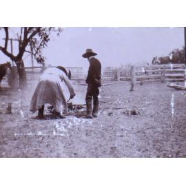 Two unidentified men tending a fire