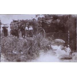 Three men and one woman at a waterfall