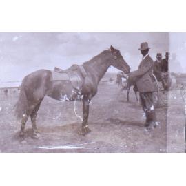 Unidentified man holding a horse