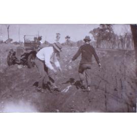 Two unidentified men in the mud