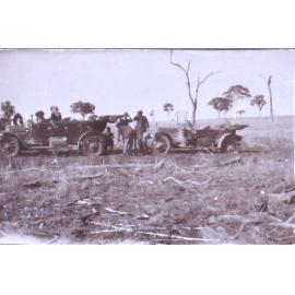 Unidentified men and women with two cars