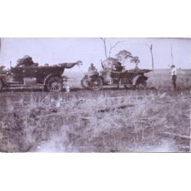 Unidentified people pulling out a bogged car with another car
