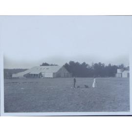 Couple with two dogs near farm buildings