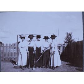 Five women with hockey sticks on rollers skates