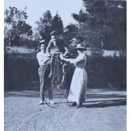 Soldier on pennyfarthing bike with a man and a woman
