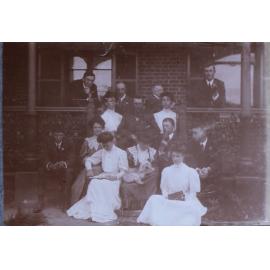 Group of eight men and six women on verandah