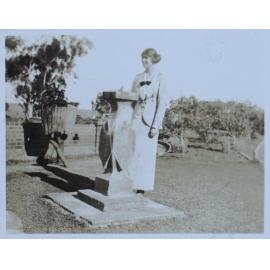 Woman standing beside a sundial