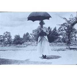 One nurse under an umbrella with a camera