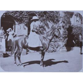 Woman on a horse in front of Booloominbah