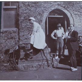 Nurse on a penny farthing outside Booloominbah