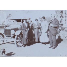 Group beside a motor car