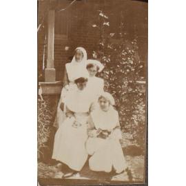 Four nurses in front of unidentified building