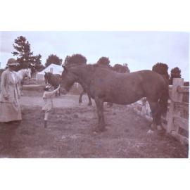 Unidentified woman and child with horses