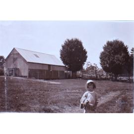Unidentified child and farm buildings
