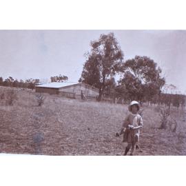 Unidentified child with farm building
