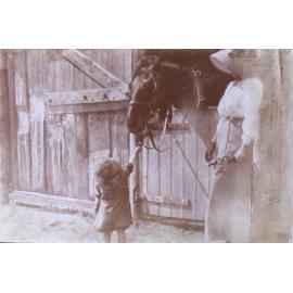 Unidentified woman and child with a horse