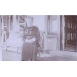 Unidentified woman sitting on a verandah