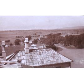View of rooftop and farmland beyond