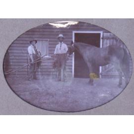 Two unidentified men with a horse