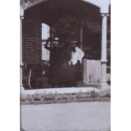 Two unidentified women on the verandah of a house