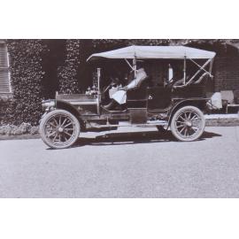 Unidentified people in a car at the front of a building