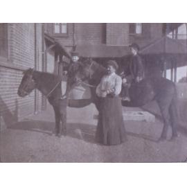 Unidentified woman with two boys on horseback