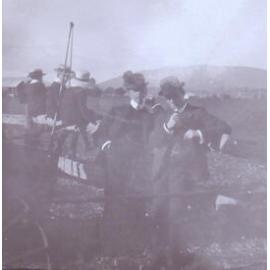 Two unidentified men with three boys sitting on the rails behind them