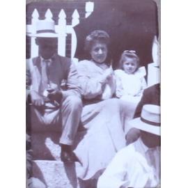 Unidentified man, woman and child on steps