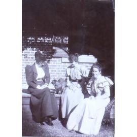 Three unidentified women with a pet dog