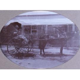 Unidentified man in a buggy outside a building