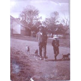 Unidentified man and boy with pet dogs