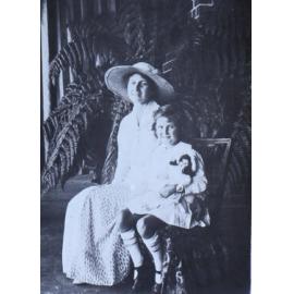 Unidentified woman and child sitting in a fernery