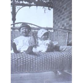 Two unidentified children sitting on a lounge