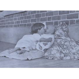 Two unidentified children sitting on cushions