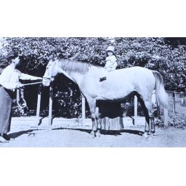 Unidentified child sitting on a horse