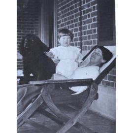 Unidentified woman and child with a pet dog